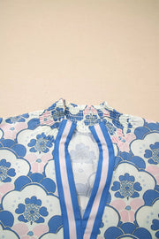 Blouse with floral print, smocked neckline, and blue and pink striped placket.