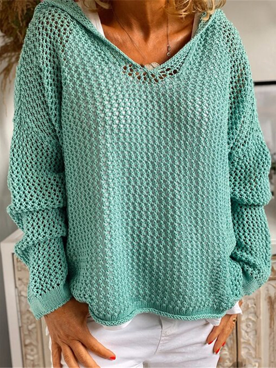 Turquoise open-knit slouchy hooded sweater with V-neck and long sleeves.