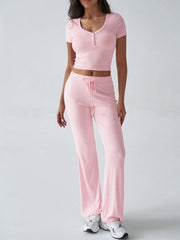 Blush pink button-front crop top and flared lounge pants set with drawstring waist.