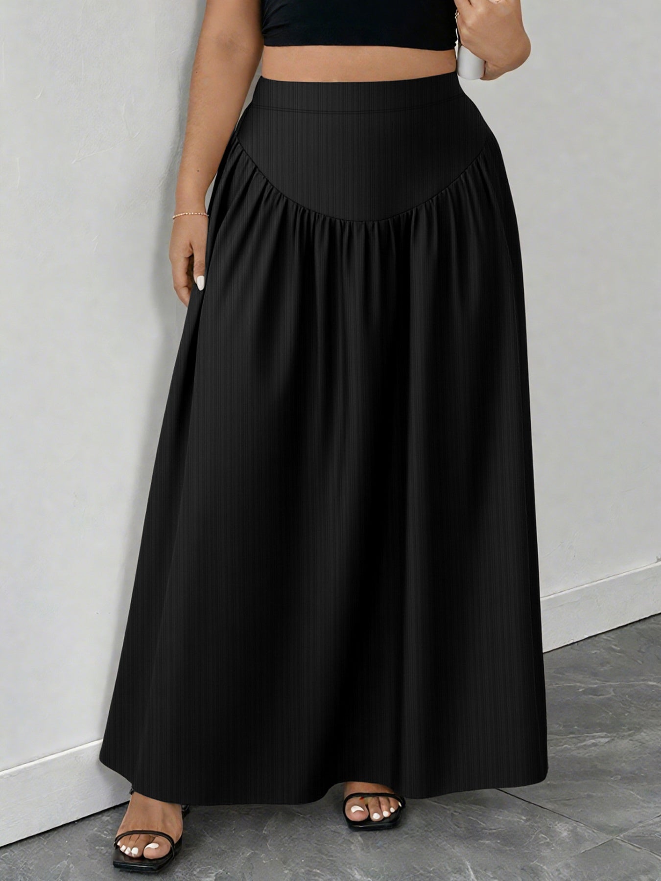 Black maxi skirt with a-line cut and gathered waist detail.