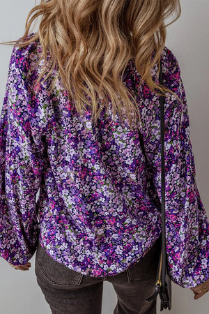 Electric purple floral print blouse with blouson sleeves and tassel detail.