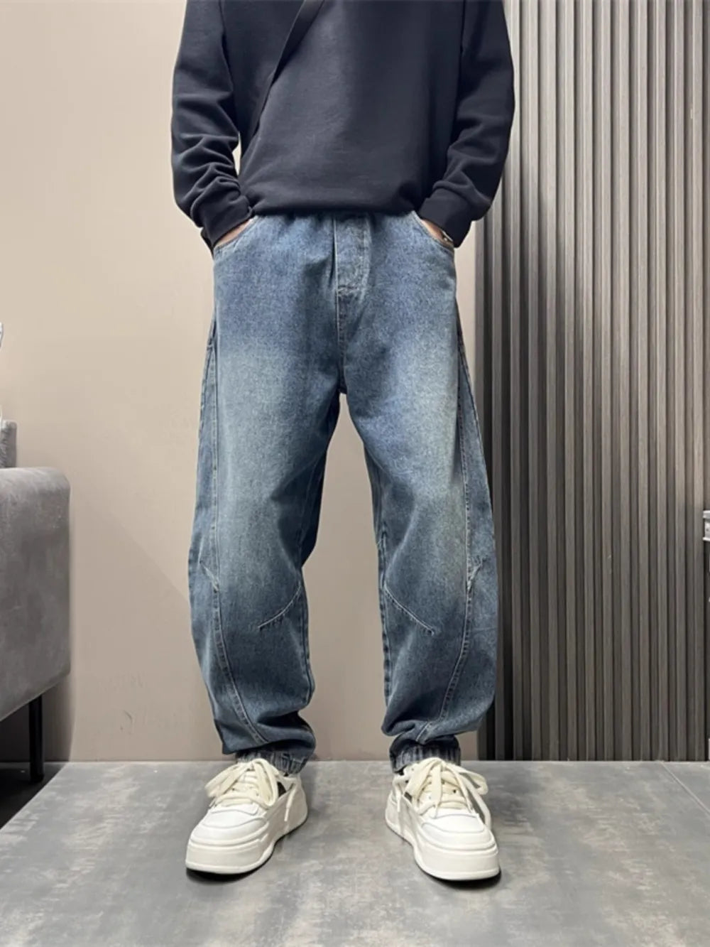 Oversized blue washed men's jeans with tapered cuffs and a baggy fit.