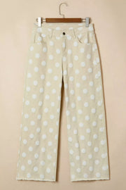 Polka dot high-waisted wide-leg jeans in beige denim with white raised polka dots and frayed hem.