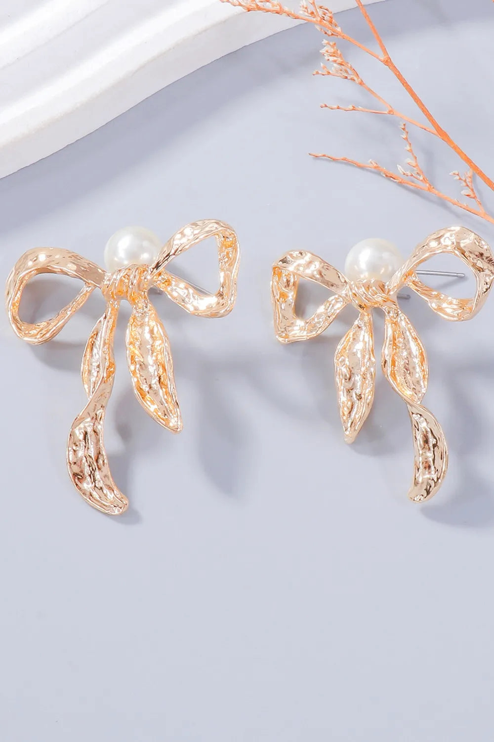 Gold textured bow earrings with pearl detail
