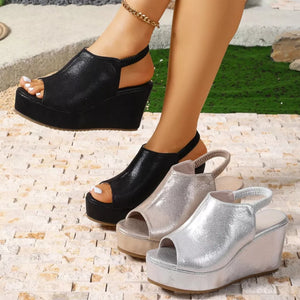 Sleek high heel wedge sandals in black, gold, and silver with peep toe and elastic slingback strap.