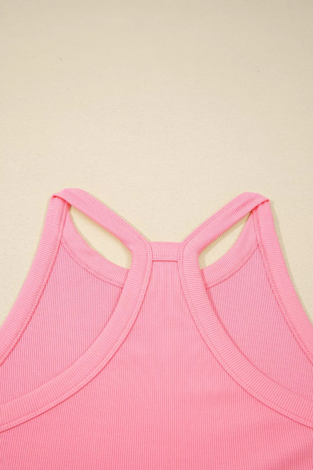 Ribbed cropped tank top in dusty pink with racerback detail and contrast trim.