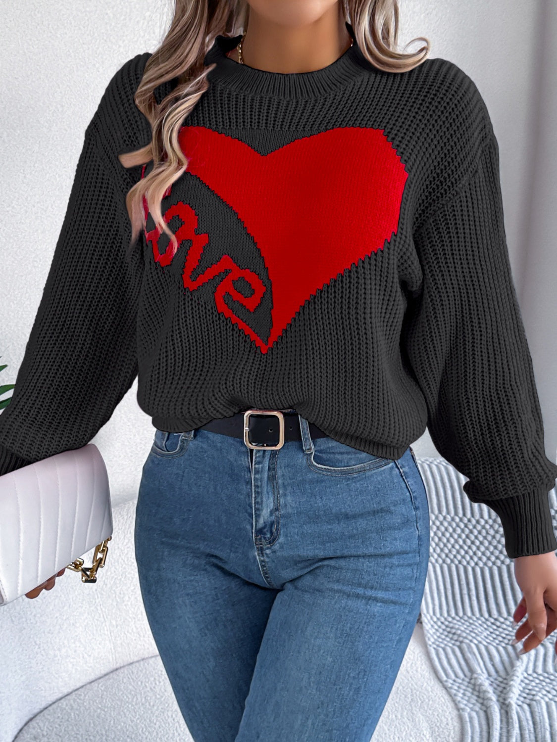 Black knit sweater with red heart and love graphic, crewneck, long sleeves.