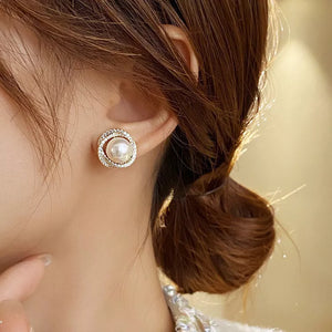 Elegant pearl and zircon stud earrings in gold with a circular design.