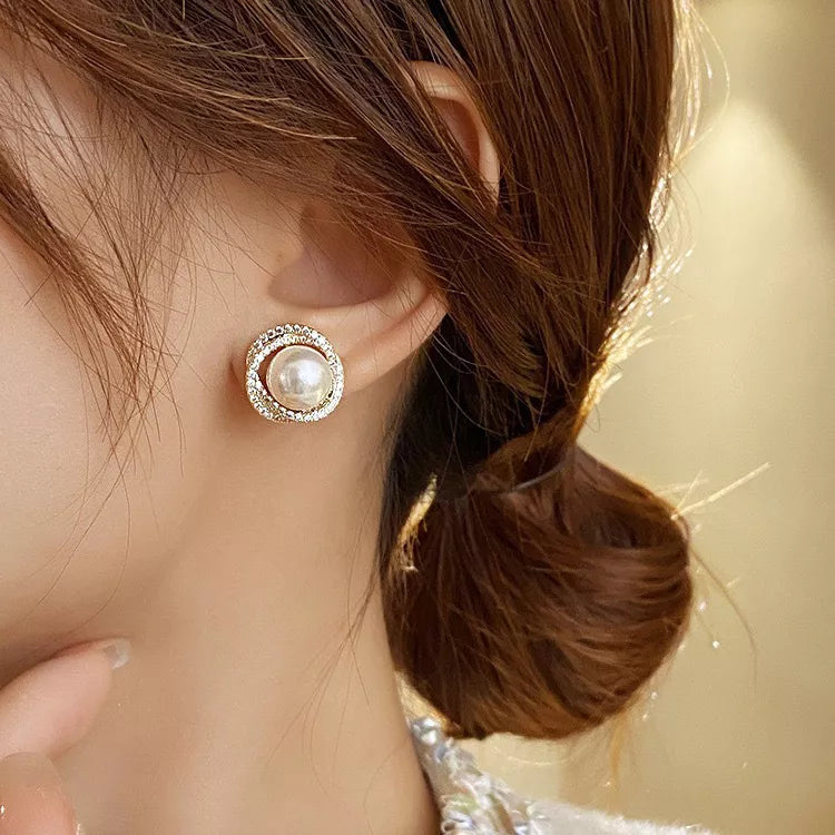 Elegant pearl and zircon stud earrings in gold with a circular design.