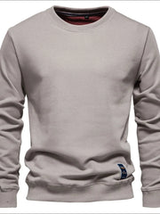 Gray crewneck sweatshirt with subtle patch detail and ribbed cuffs and hem.