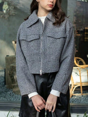 Gray cropped zip-up jacket with pockets and collar, styled with a white shirt and black shorts.