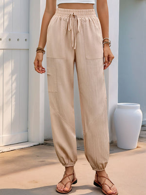 Tan textured drawstring cargo pants with elastic cuffs and pockets.