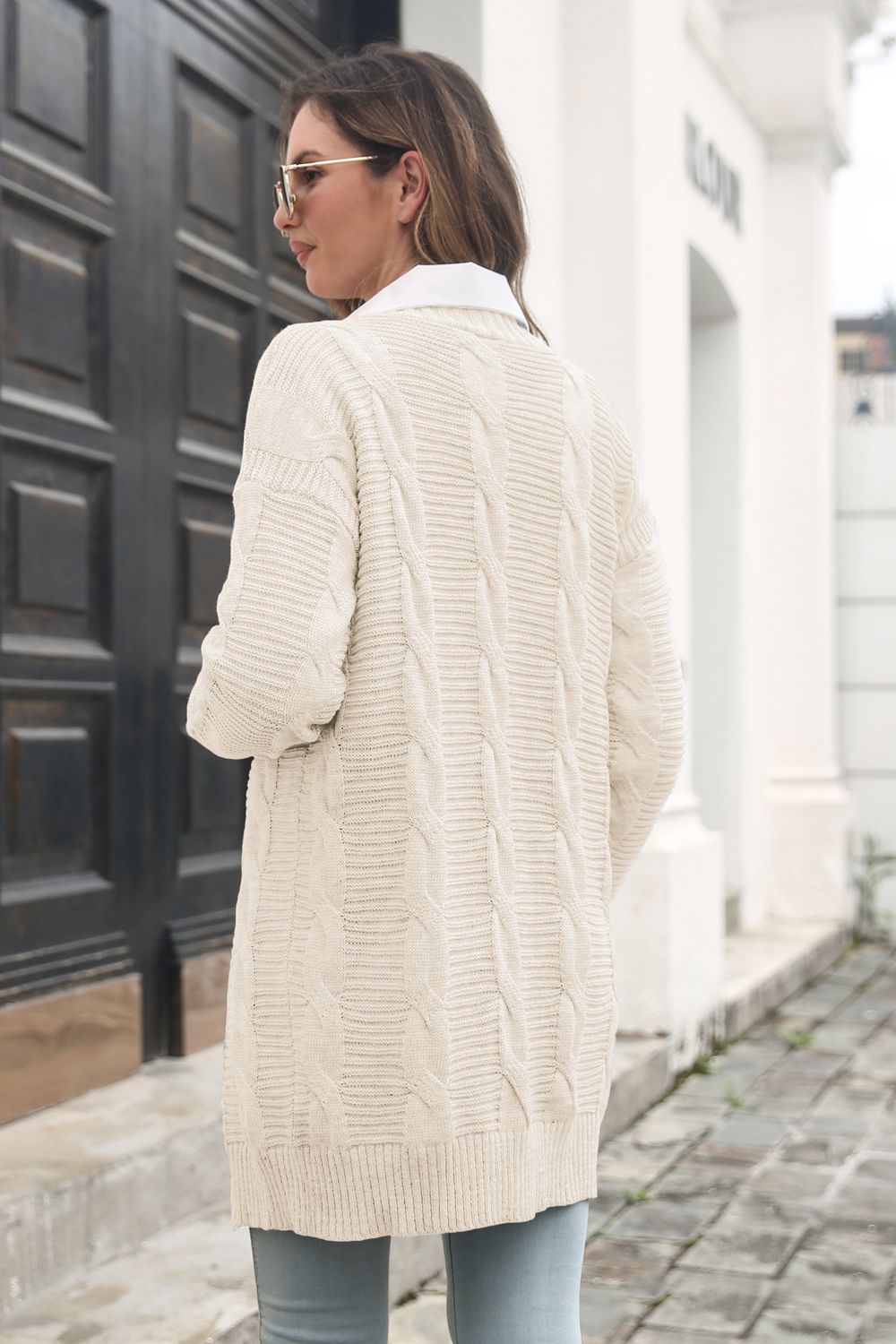 Longline cable knit cardigan in ivory with classic cable knit pattern and ribbed trim.