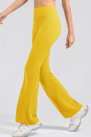 Yellow flare leggings with a high waist, shown on a model walking.