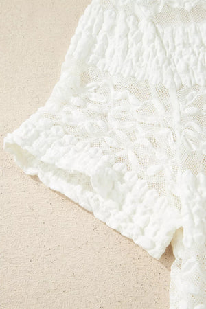 White sheer lace patchwork t-shirt with textured floral details and ruffled sleeves.