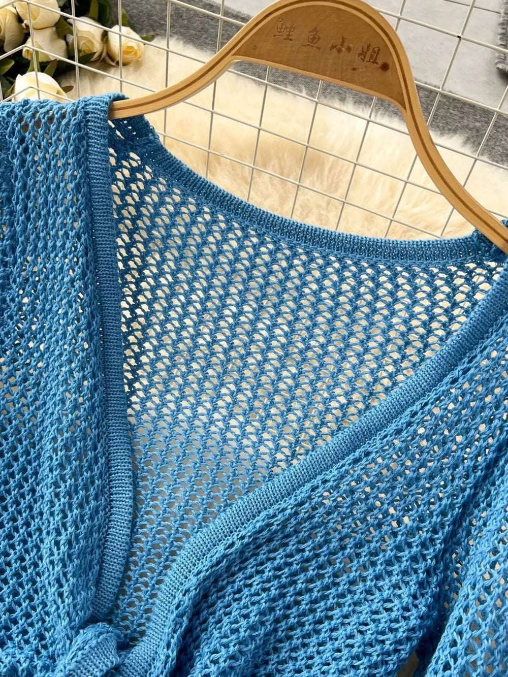 Blue crochet tied crop top with V-neck and open front detail.