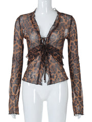 Chic tied animal print sheer blouse with ruffled neckline and cuffs.