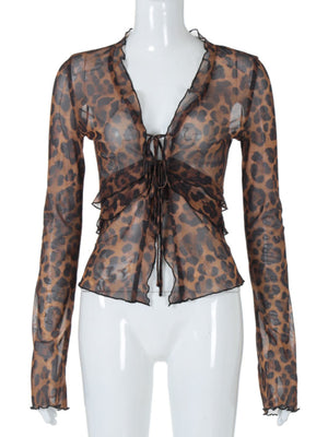 Chic tied animal print sheer blouse with ruffled neckline and cuffs.