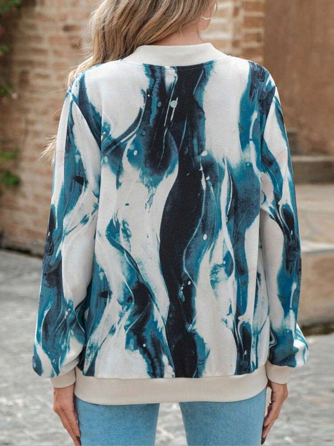 Fluid abstract bomber jacket in teal and white with a crew neck and ribbed cuffs.