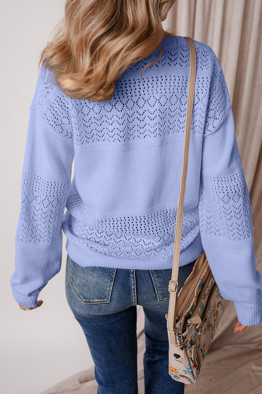 Light blue perforated knit v-neck pullover sweater with open knit details on sleeves and back.