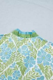 Mini dress with blue floral print, green leaves, and ruffled collar detail.