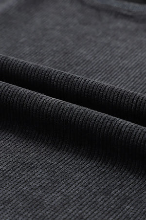 Black ribbed sweatshirt fabric detail showing texture and weave