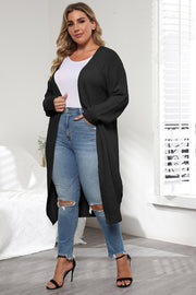 Black oversized knit maxi cardigan with V-neck and long sleeves, styled with jeans.
