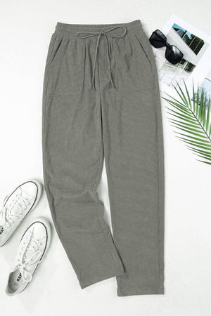 Corduroy drawstring trousers in dark gray with slant pockets and a relaxed fit.