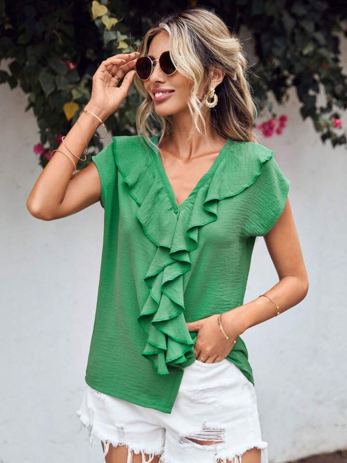 Green V-neck blouse with ruffled front and cap sleeves.