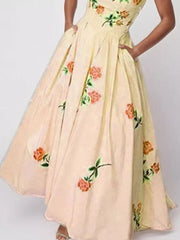 Floral print tube maxi dress in blush pink with orange roses and green leaves, featuring pockets.