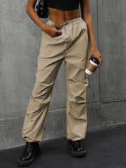 Khaki gathered-leg utility trousers with cuffed ankles and drawstring waist.