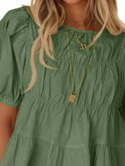 Light green maternity blouse with puff sleeves, ruffled neckline, and tiered hem.