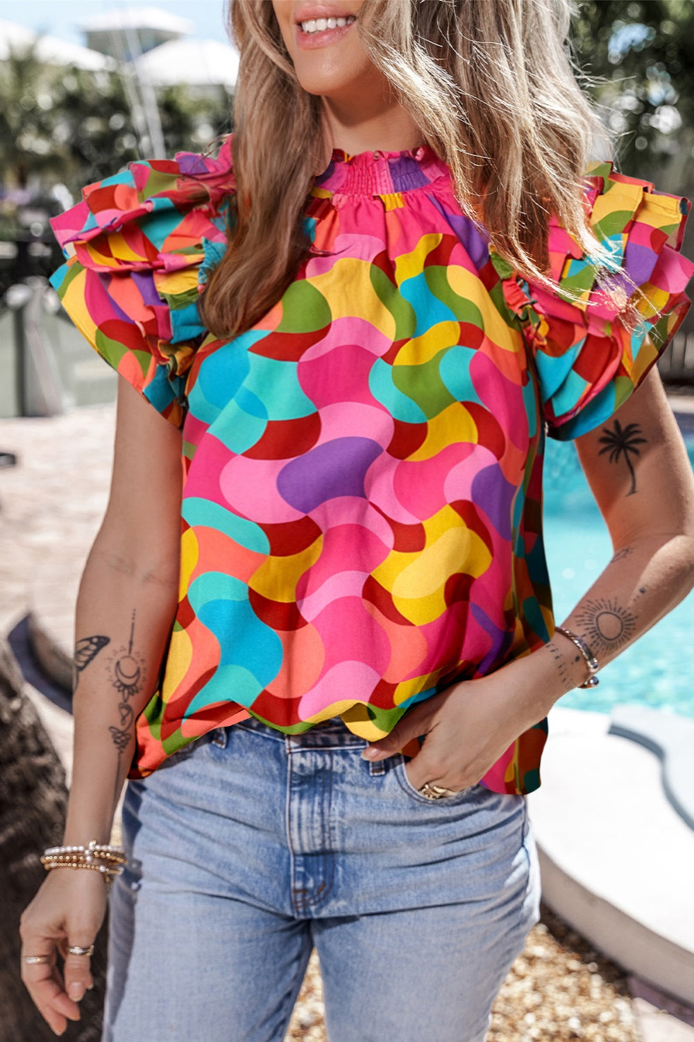 Kaleidoscope ruffle sleeve smocked blouse in hot pink with a colorful abstract print.