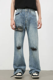 Distressed flare leg jeans in medium wash denim with ripped details.