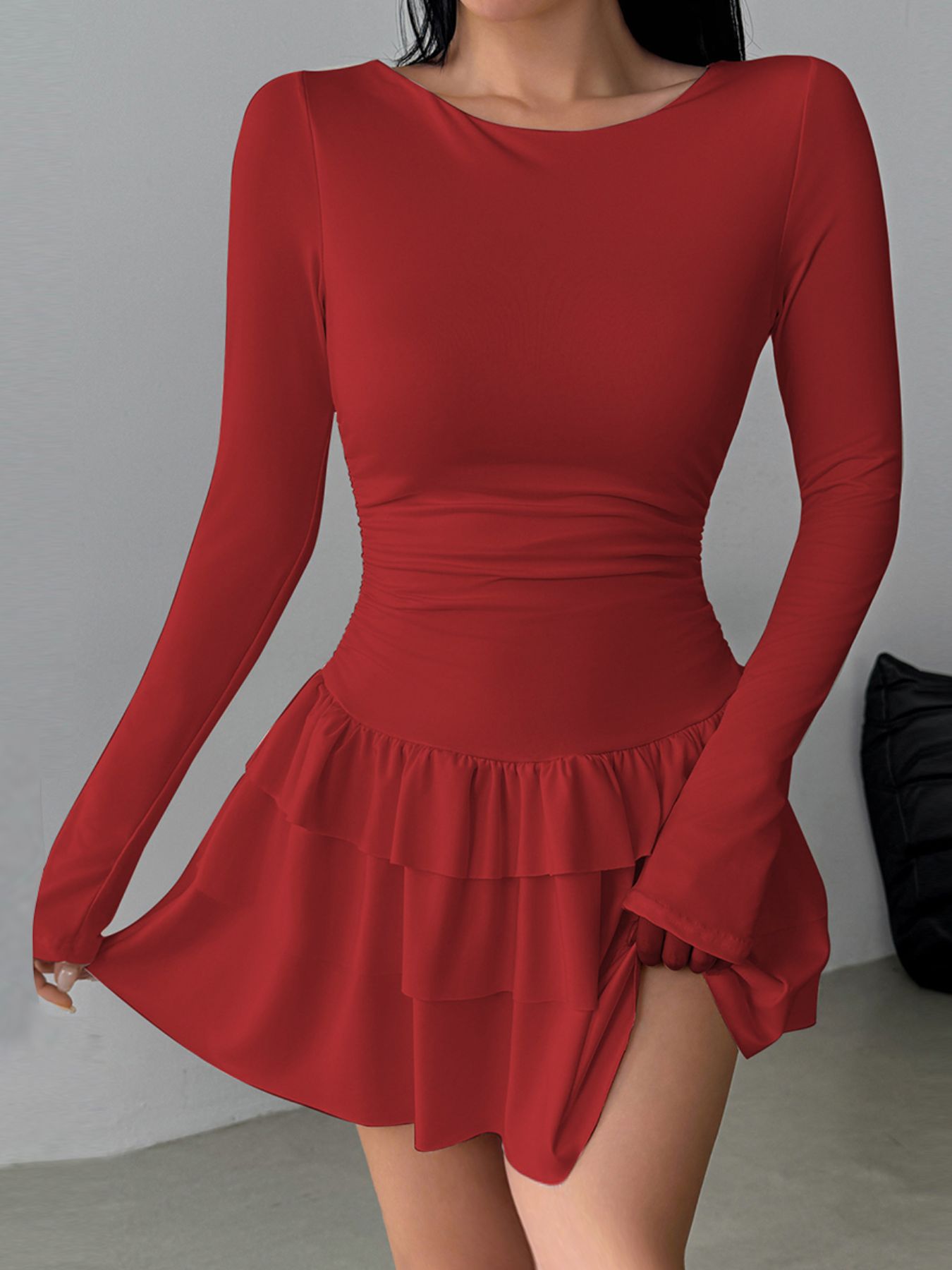 Red long sleeve mini dress with tiered ruffle hem and ruched waist detail.