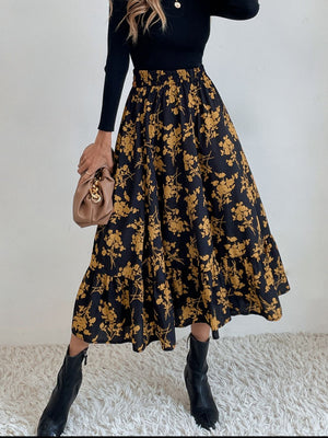 Tiered midi skirt in black with yellow floral print and ruffled hem.