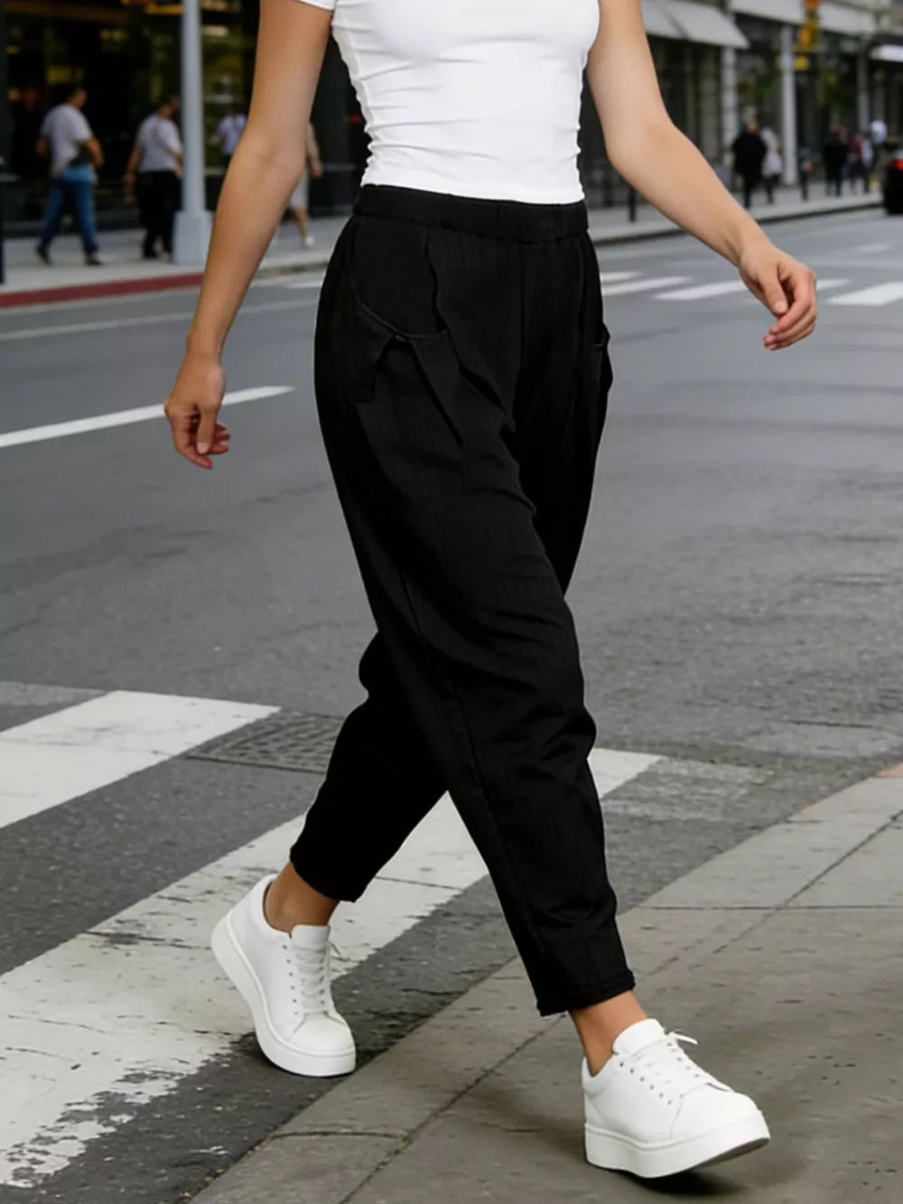 Black harem maternity joggers with pockets and pinstripe detail.
