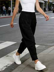 Black harem maternity joggers with pockets and pinstripe detail.