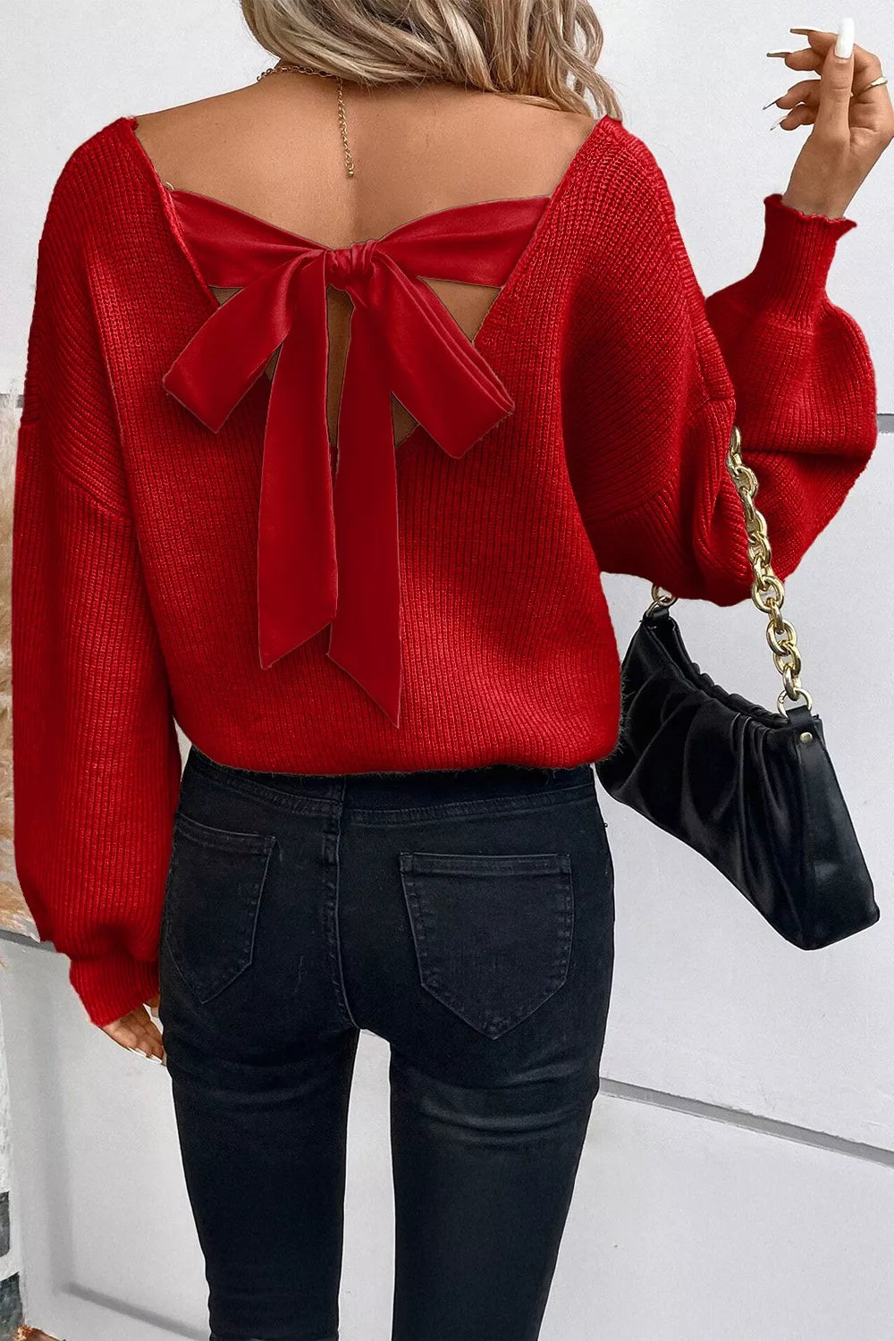Red backless knit sweater with velvet bow detail and balloon sleeves.
