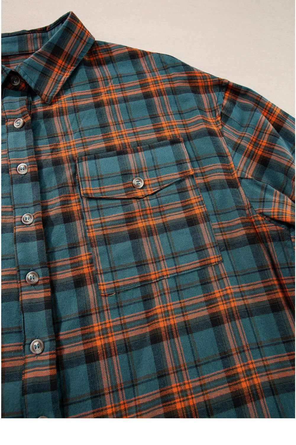 Oversized plaid overshirt in teal with orange and black plaid, featuring a button-front, collar, and chest pocket.