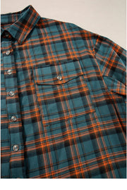 Oversized plaid overshirt in teal with orange and black plaid, featuring a button-front, collar, and chest pocket.