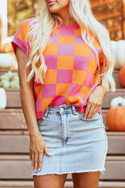 Checkerboard knit cap-sleeve top in plaid pink and orange with a crew neck.