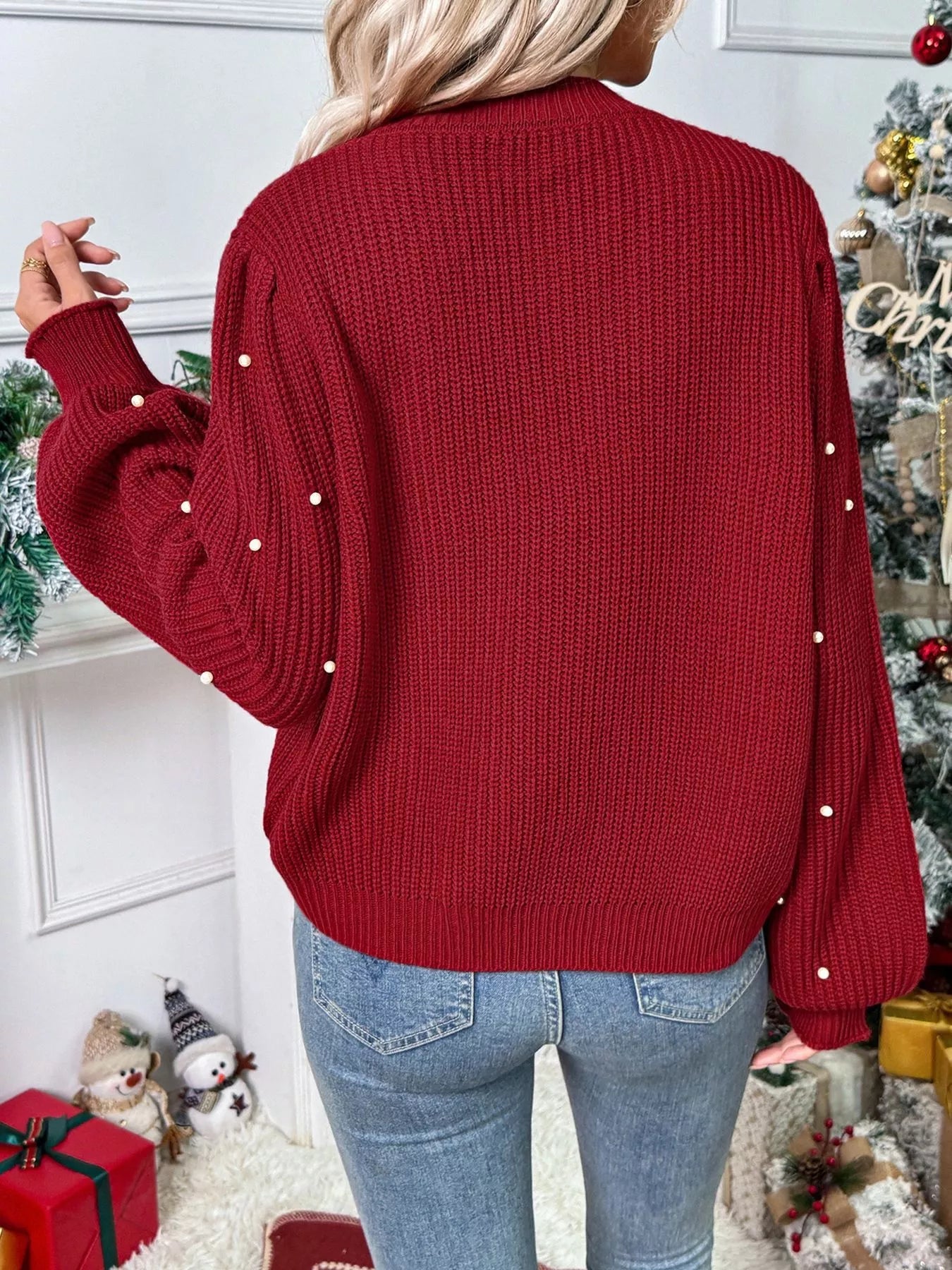 Red acrylic knit cardigan with pearl embellishments on sleeves and back.