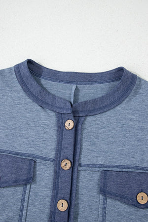 Dusty blue jumpsuit with denim trim, button front, and chest pockets.