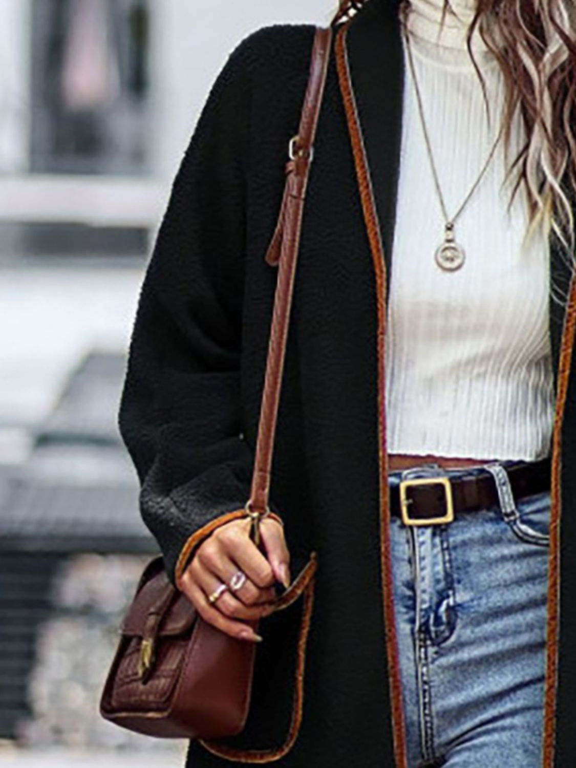 Black teddy coat with contrast trim detailing and a textured finish.