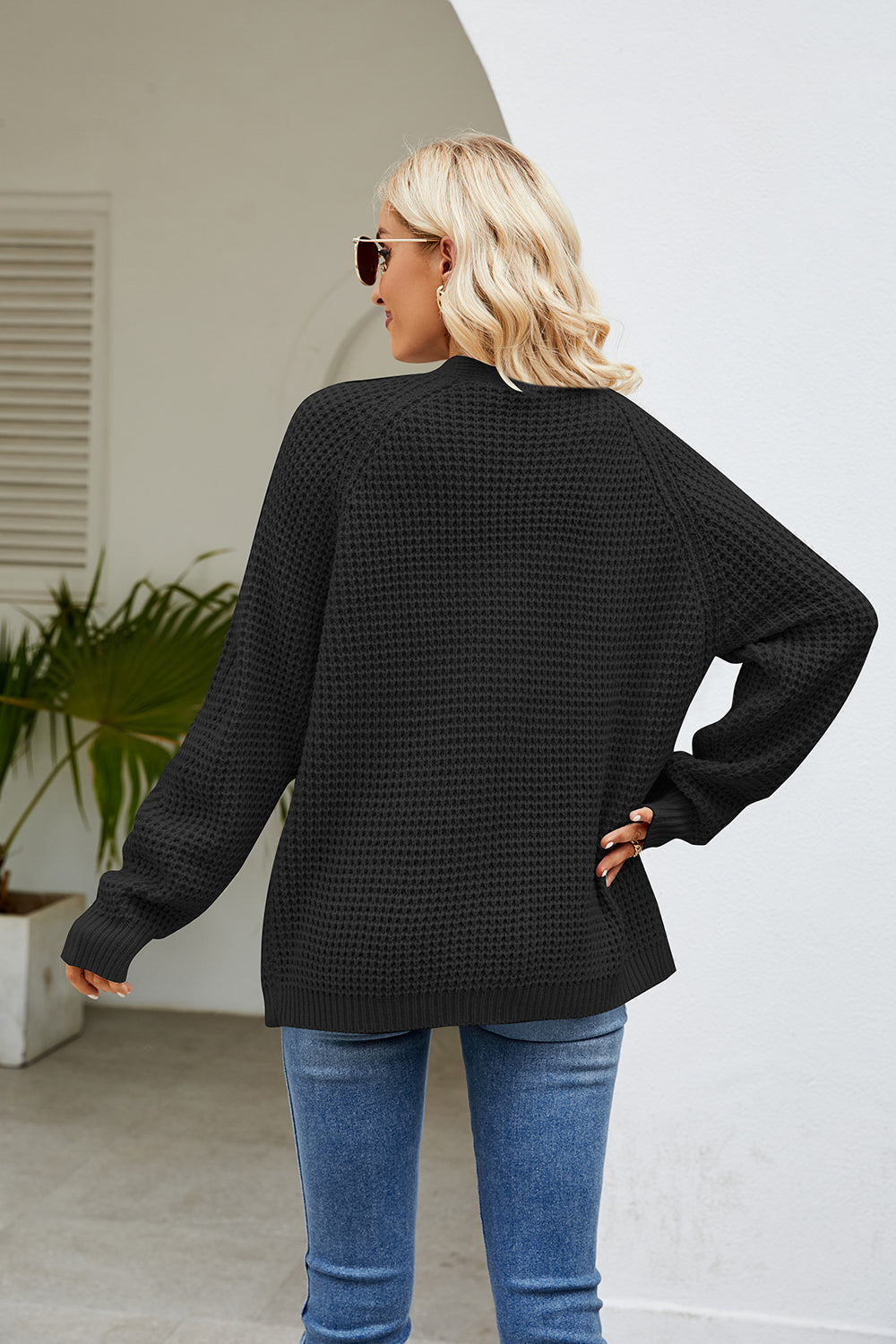 Black waffle knit raglan pocket cardigan with long sleeves and crew neck.