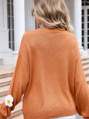 Ochre knit sweater with balloon sleeves and a daisy appliqué detail on the left sleeve.