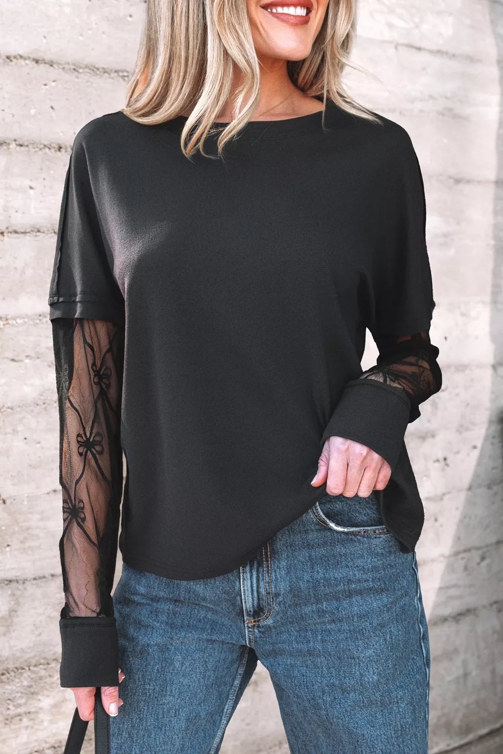 Black relaxed fit t-shirt with sheer lace sleeves featuring a bow pattern.