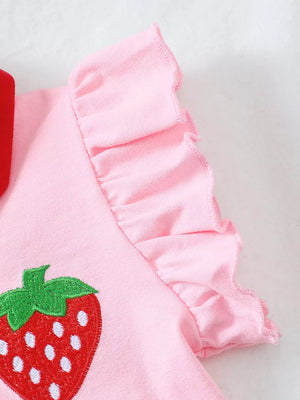Pink cotton polo with strawberry embroidery and ruffled sleeves.