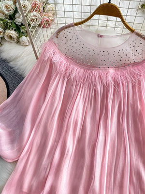 Pink sheer blouse with rhinestone neckline and feather trim.